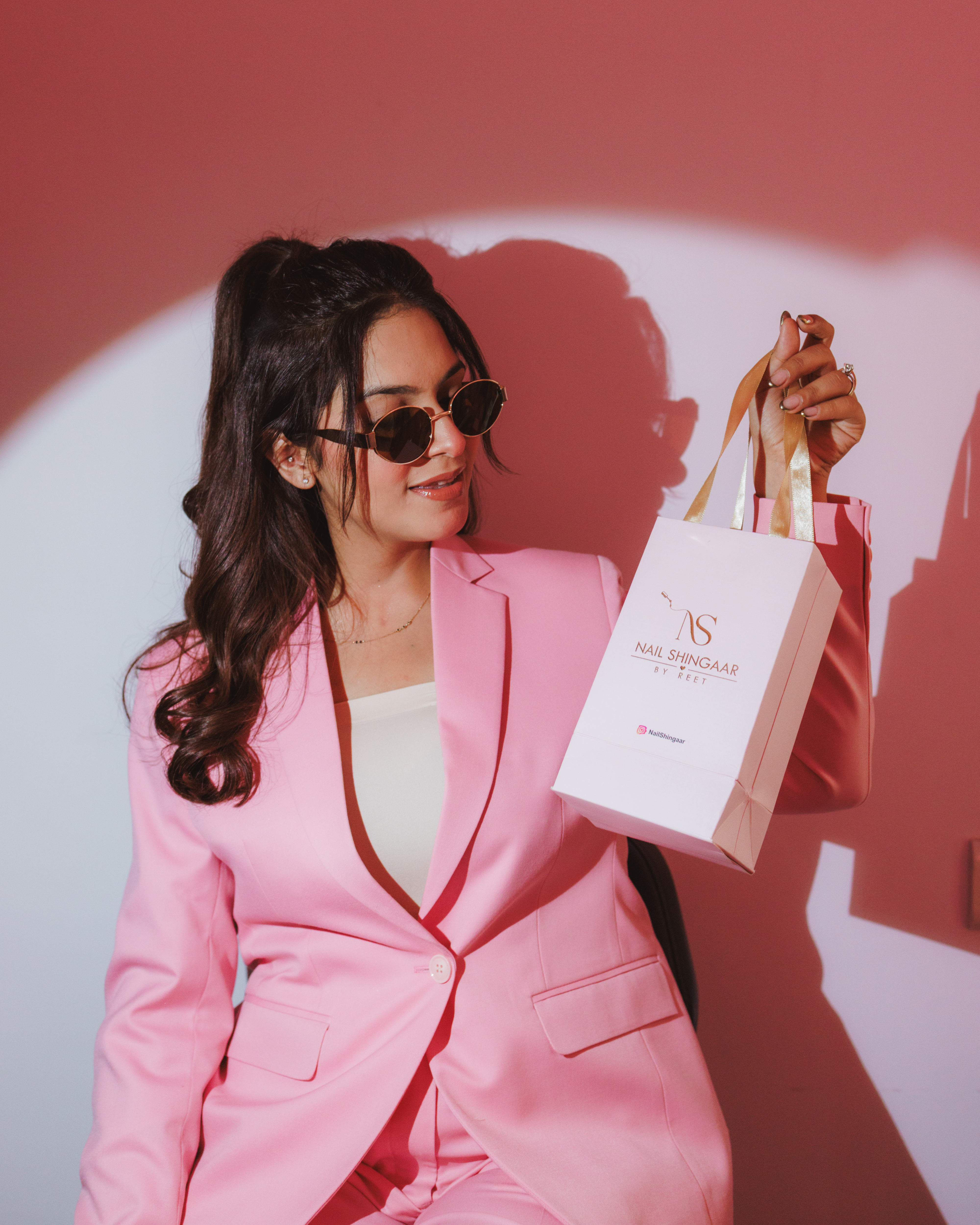 Reet Rajpal, nail artist and founder of Nail Shingaar, holding a Nail Shingaar gift bag